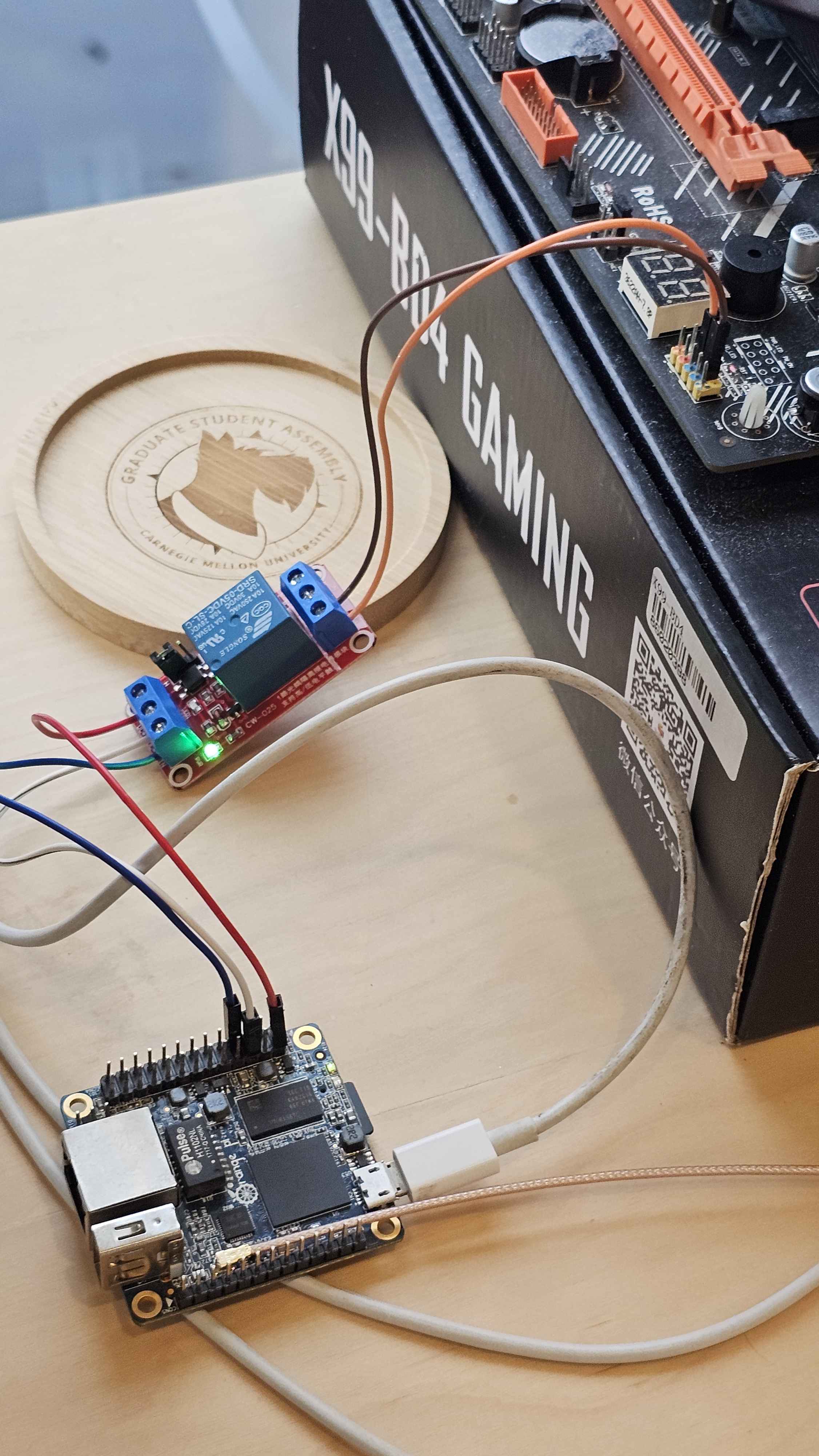 Orange Pi Zero GPIO header wired to the relay module, with the relay's output leads running to the motherboard